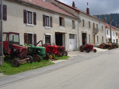 Oude tractoren in een straat in het centrum van Chaux-Neuve Oude tractoren in een straat in het centrum van Chaux-Neuve