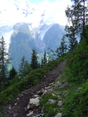 Smal dalend bergpad en zicht op gletsjers van Mont Blanc Smal dalend bergpad en zicht op gletsjers van Mont Blanc